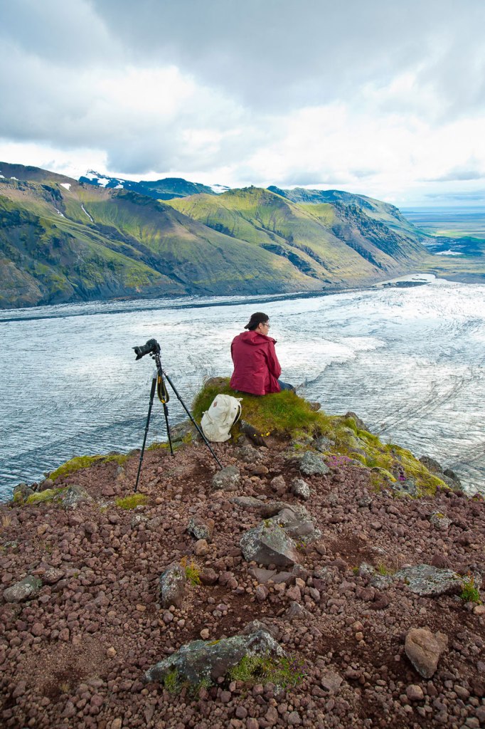 Kollege gönnt sich eine Verschnaufpause beim Fotografieren der Landschaft Islands